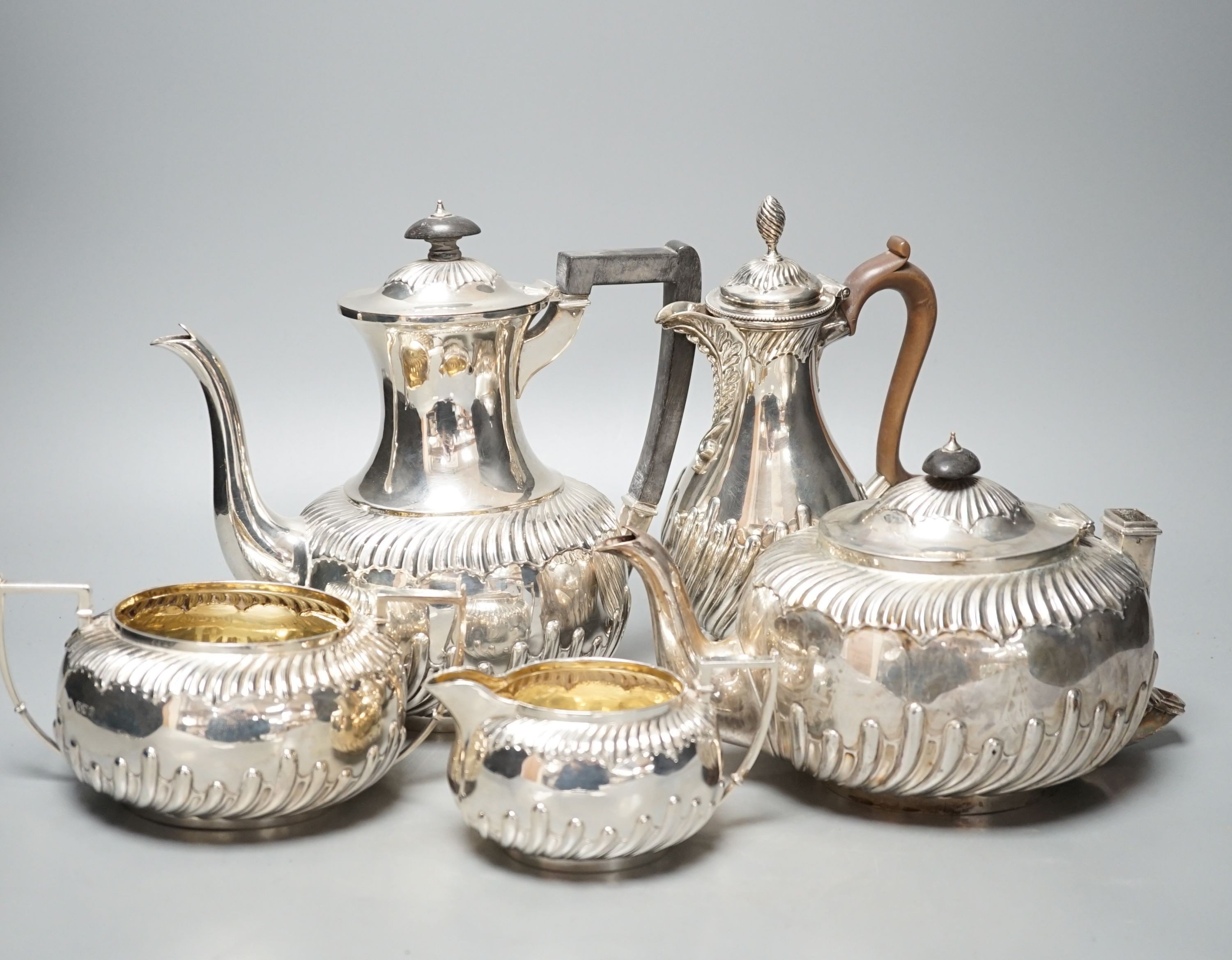 A late Victorian repousse silver four piece tea set, Martin, Hall & Co, Sheffield, 1892, (a.f.) together with a Victorian silver hot water jug, Charles Stuart Harris, London, 1884, gross 60.5oz.